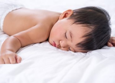 baby sleeping on a bed